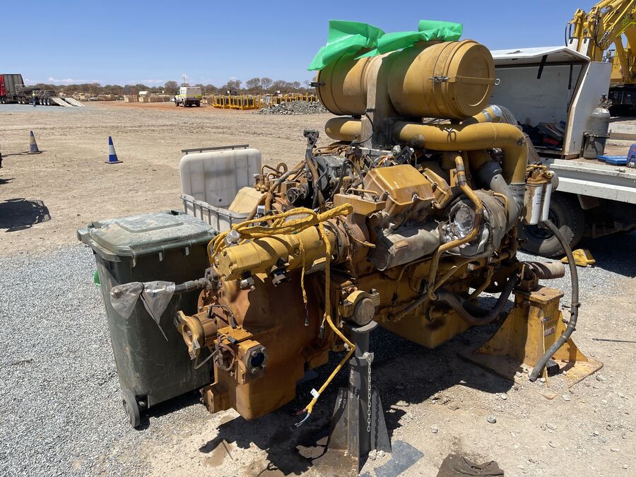 Diesel engine removed from a machine and sitting on the ground beside a service vehicle