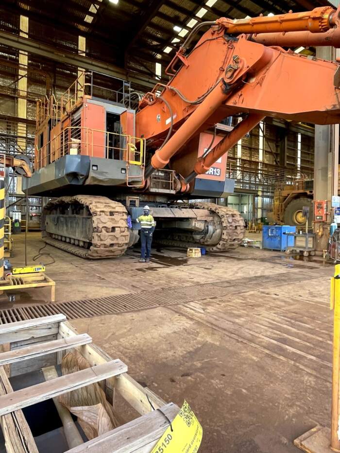 Large tracked excavator inside a workshop bay